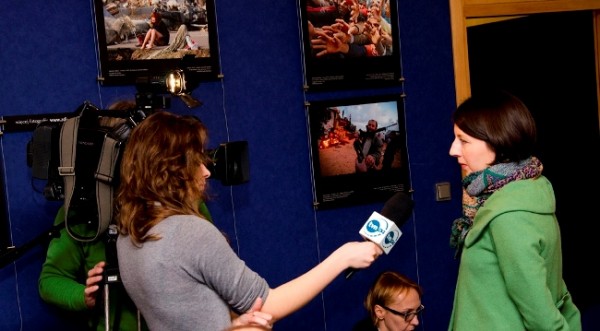 a woman is being interviewed by a reporter who holds a large microphone